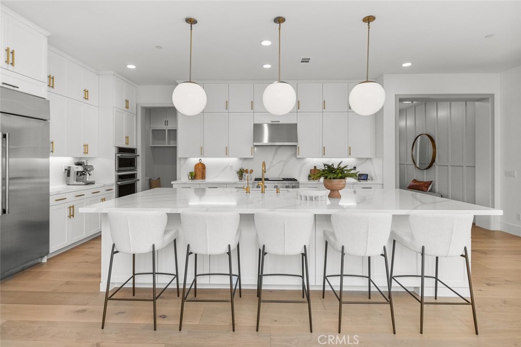 39504 Caladium Drive Temecula, CA 92591 - Photo 6 of 38 a kitchen with a dining table cabinets and stainless steel appliances