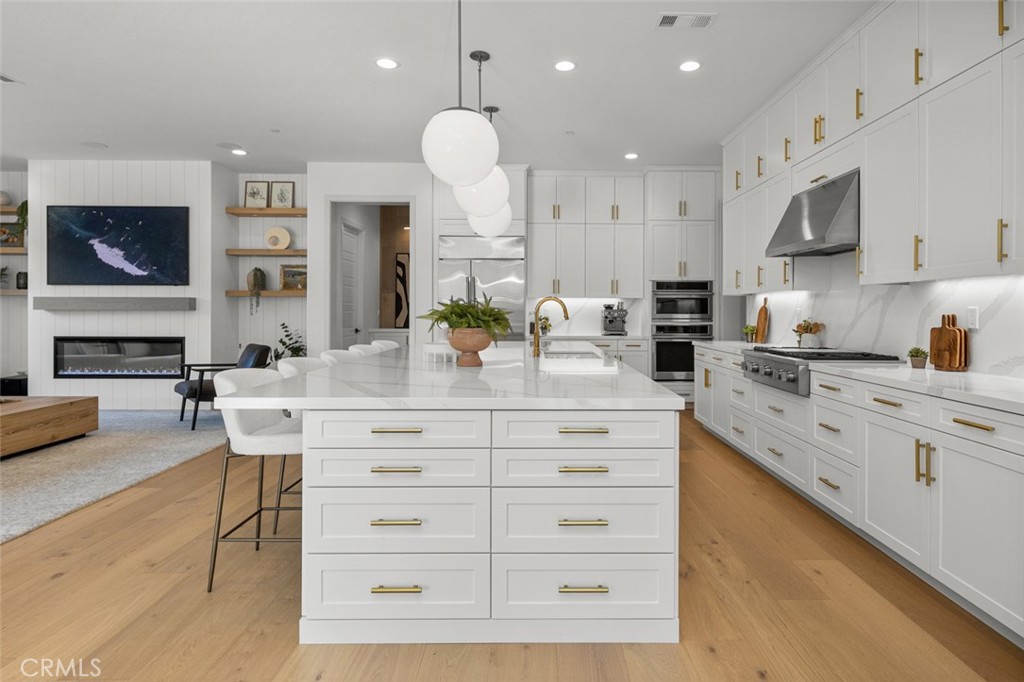 39504 Caladium Drive Temecula, CA 92591 - Photo 7 of 38 a kitchen with stainless steel appliances kitchen island granite countertop a stove a sink and a microwave