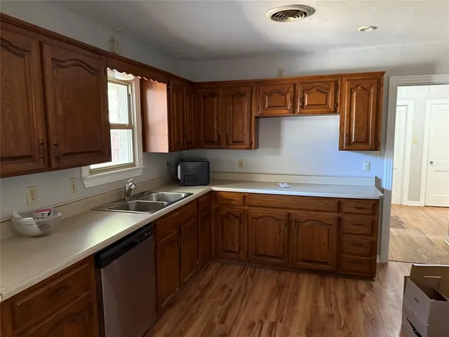 a kitchen with stainless steel appliances granite countertop wooden cabinets a sink and dishwasher