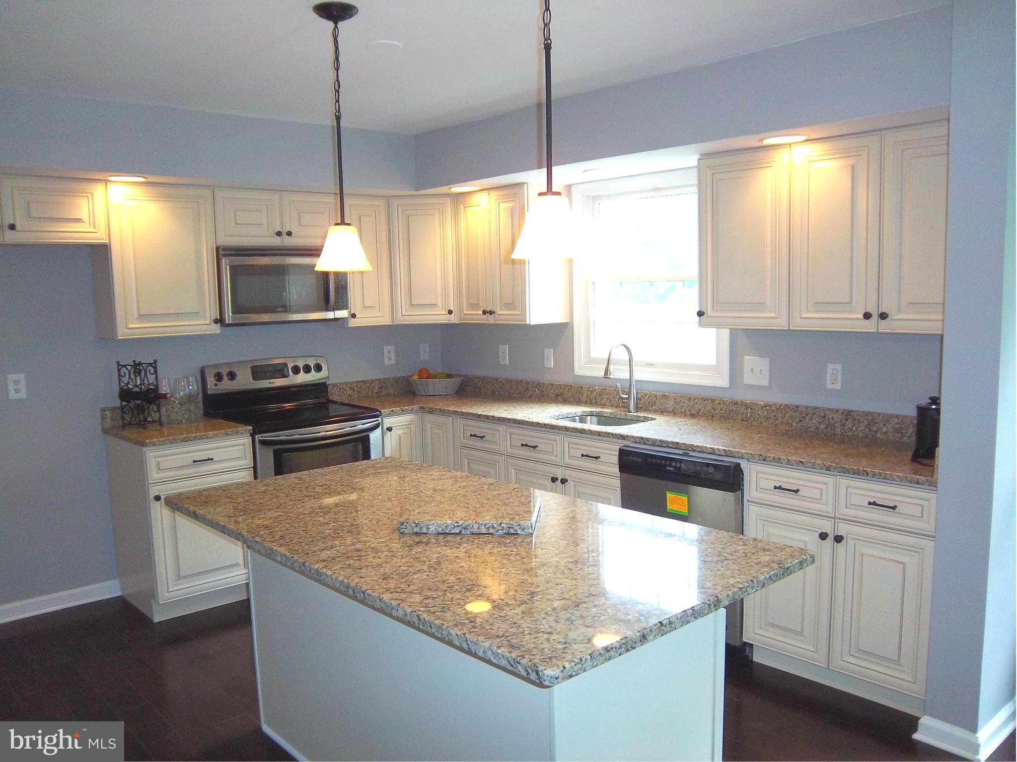 7917 Quarterfield Road Severn, MD 21144 - Photo 4 of 27 a kitchen with stainless steel appliances granite countertop a sink a stove and a refrigerator