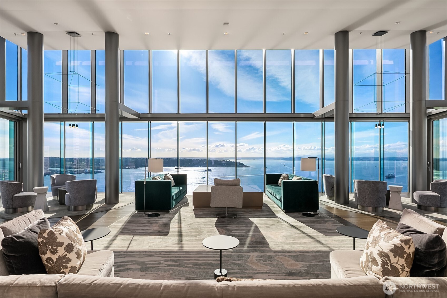 a living room with furniture large windows and wooden floor