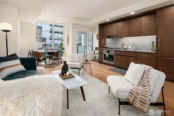 a living room with furniture wooden floor and kitchen view