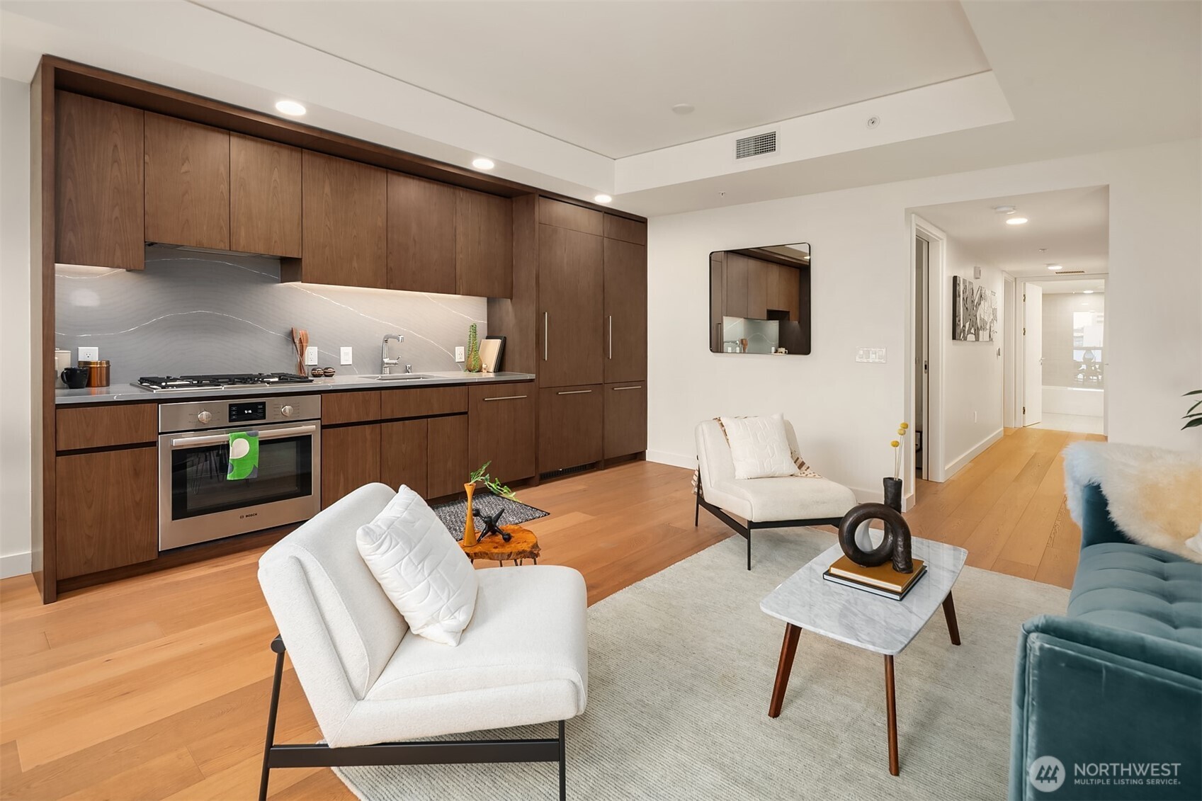 121 Stewart Street, Unit 1304 Seattle, WA 98101 - Photo 6 of 25 a kitchen with stainless steel appliances kitchen island granite countertop a sink and cabinets