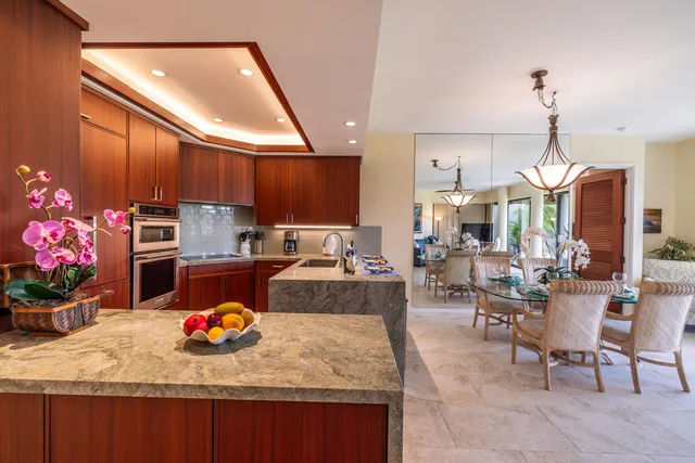 a kitchen with microwave a refrigerator and chairs
