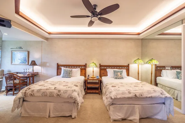 a bedroom with two separate beds and painting on the wall