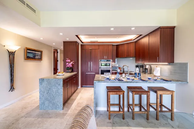 a kitchen with granite countertop a table chairs microwave and cabinets
