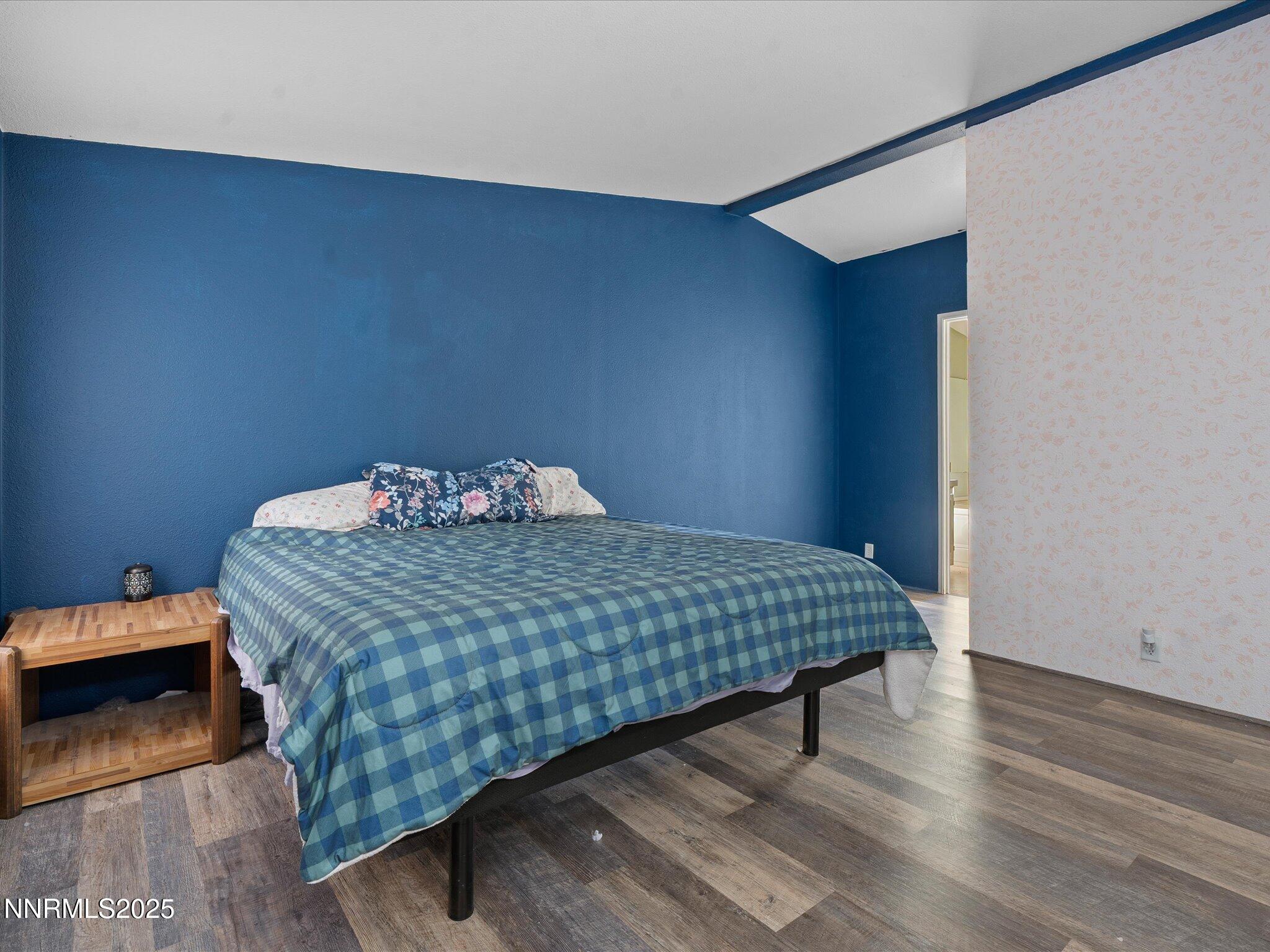 227 Walker Street Gardnerville, NV 89410 - Photo 18 of 33 a bedroom with a bed and wooden floor