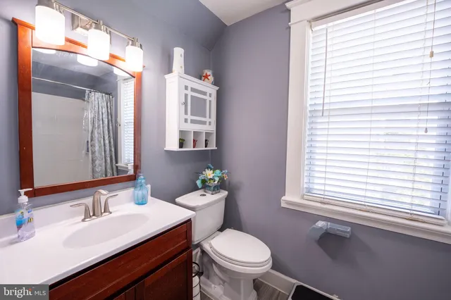 a bathroom with a granite countertop toilet sink and mirror
