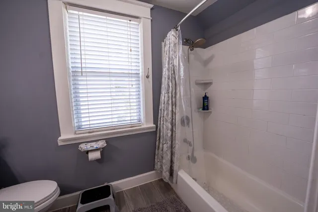 a bathroom with a bathtub toilet and window