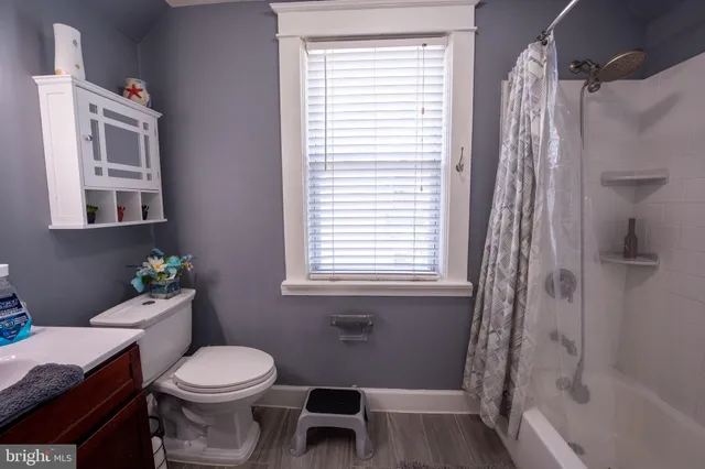 a white toilet sitting next to a bath tub