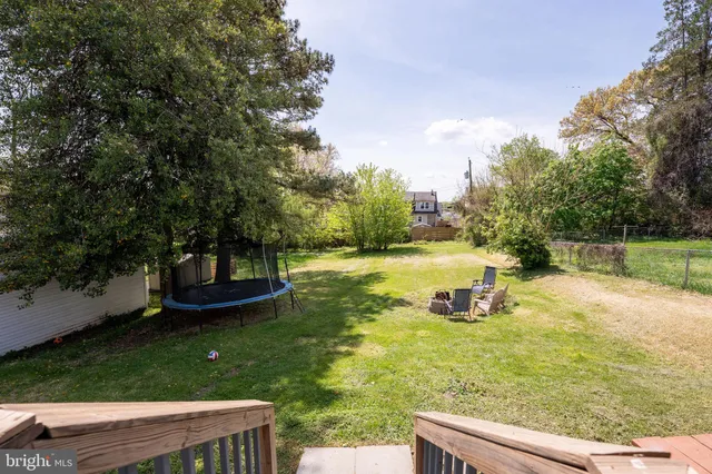 a view of a house with a big yard and large trees