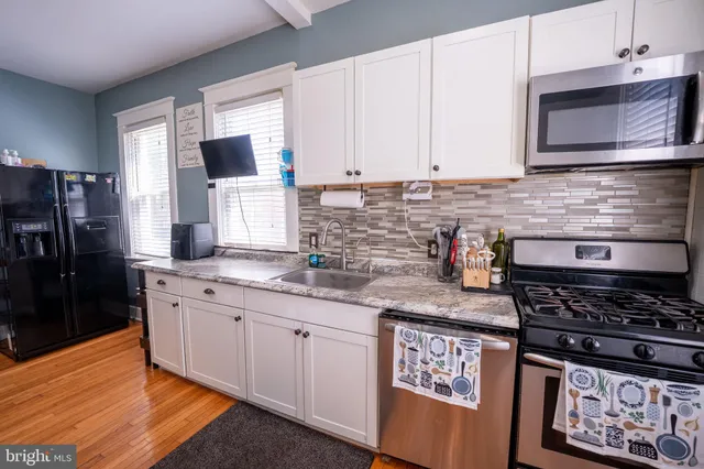 a kitchen with stainless steel appliances granite countertop a stove sink and cabinets