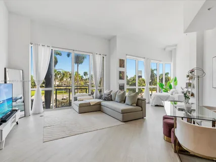 a living room with fireplace furniture and a large window