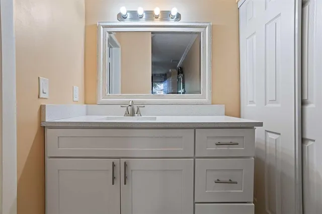 a bathroom with a sink vanity and mirror