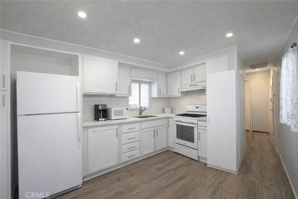 3734 Pacific Street, Unit 40 Highland, CA 92346 - Photo 2 of 15 a kitchen with white cabinets and white appliances