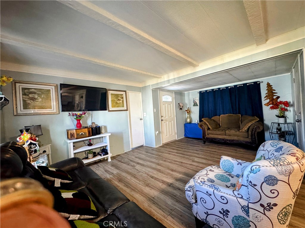 3734 Pacific Street, Unit 40 Highland, CA 92346 - Photo 5 of 15 a bedroom with furniture and a flat screen tv