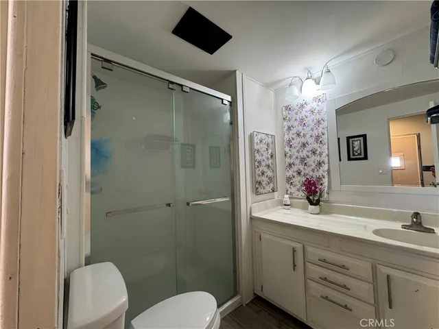 a bathroom with a sink toilet a mirror a vanity and shower