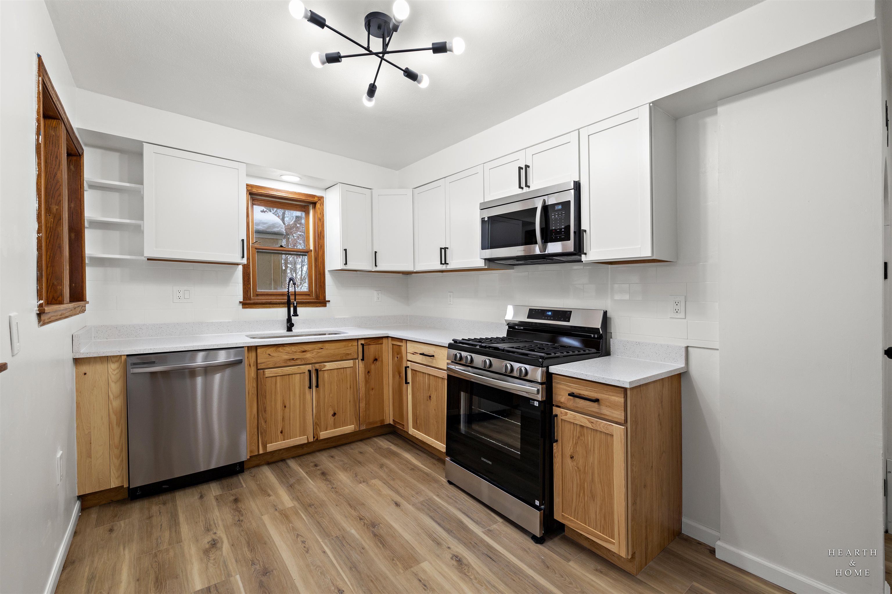 1016 B Street Rockford, IL 61107 - Photo 4 of 38 a kitchen with stainless steel appliances granite countertop a sink a stove top oven a refrigerator with white cabinets and wooden floor