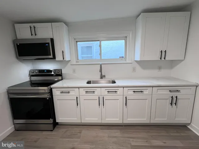 a kitchen with white cabinets stainless steel appliances and a sink