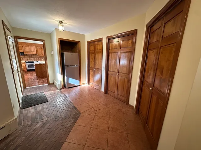 a view of a hallway with wooden floor and cabinet