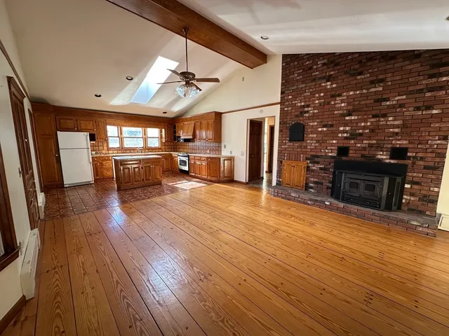 a view of a livingroom with furniture a fireplace and wooden floor