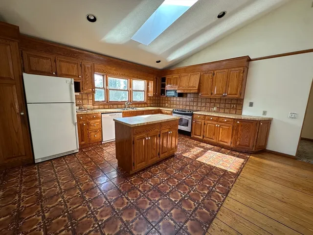 a kitchen with stainless steel appliances granite countertop a stove a sink and a refrigerator