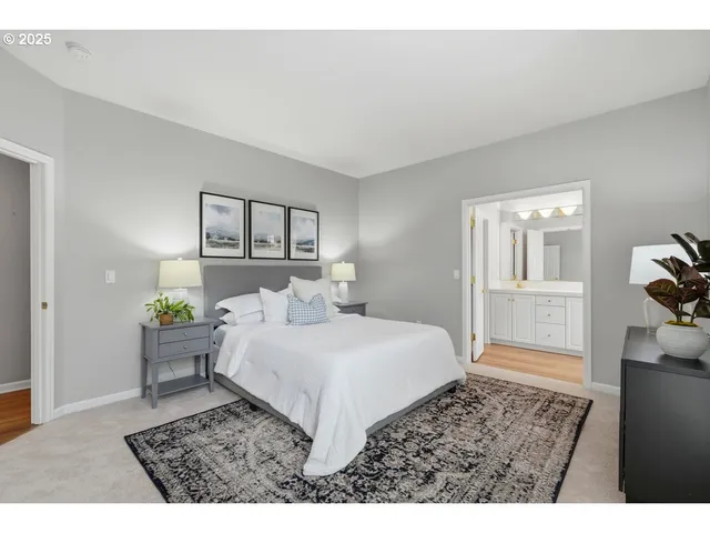 a bedroom with a bed a mirror and a potted plant