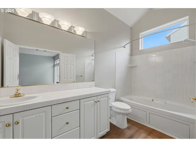 a bathroom with a double vanity sink toilet and a mirror