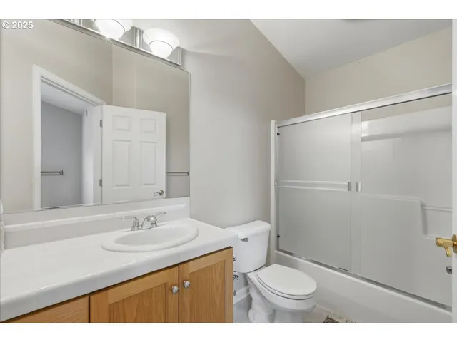 a bathroom with a sink toilet vanity and shower