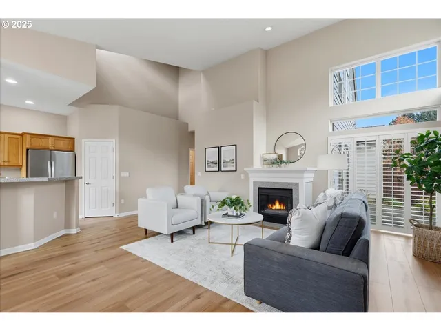 a living room with furniture a fireplace and a large window