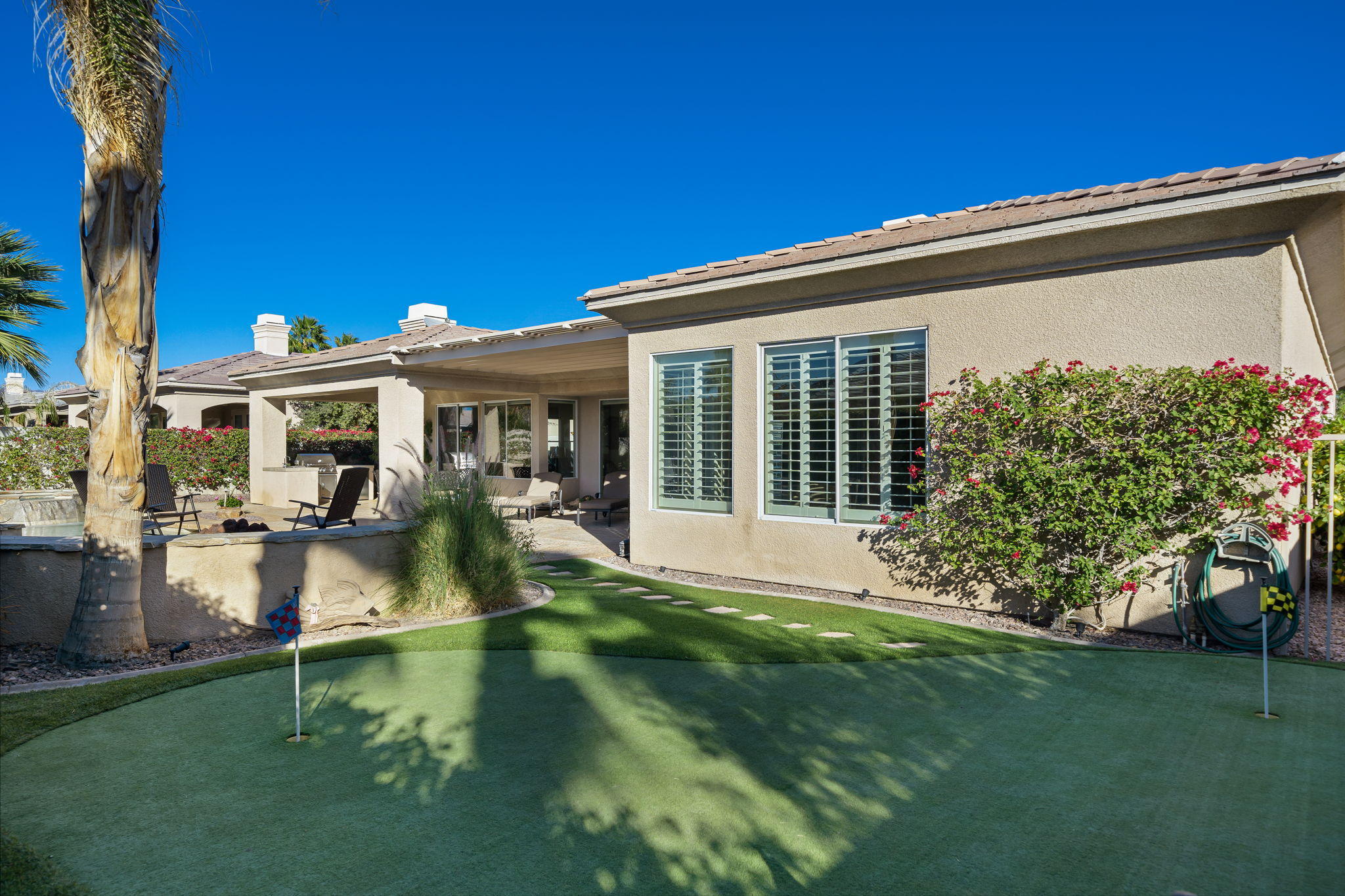 1 Orleans Road Rancho Mirage, CA 92270 - Photo 34 of 50 a front view of a house with garden and swimming pool