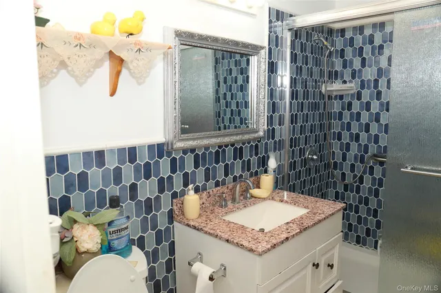 a bathroom with a granite countertop sink a toilet and shower