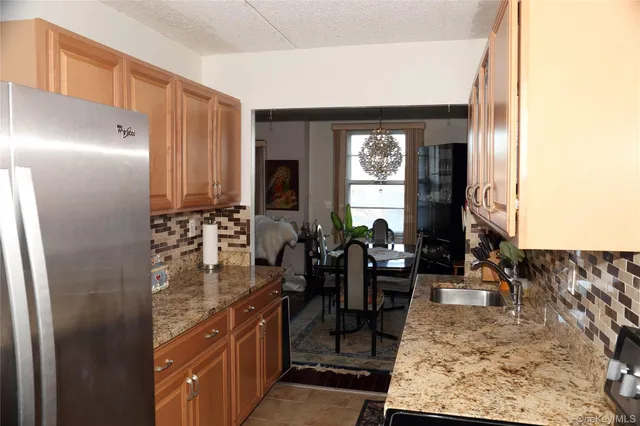 a kitchen with stainless steel appliances granite countertop a refrigerator and a sink