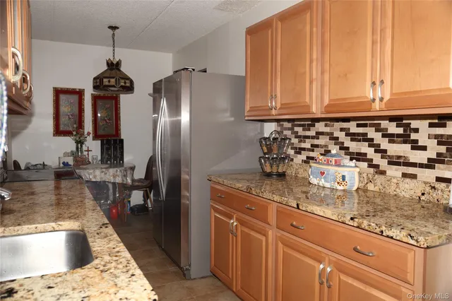 a kitchen with granite countertop stainless steel appliances a sink stove and refrigerator