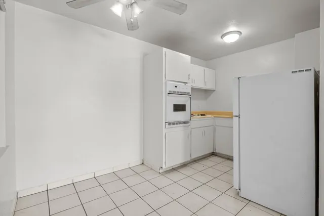 a kitchen with white cabinets and white appliances