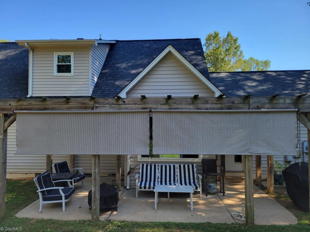 8202 Daltonshire Drive Oak Ridge, NC 27310 - Photo 3 of 49 Back patio with roll down shades and pergola
