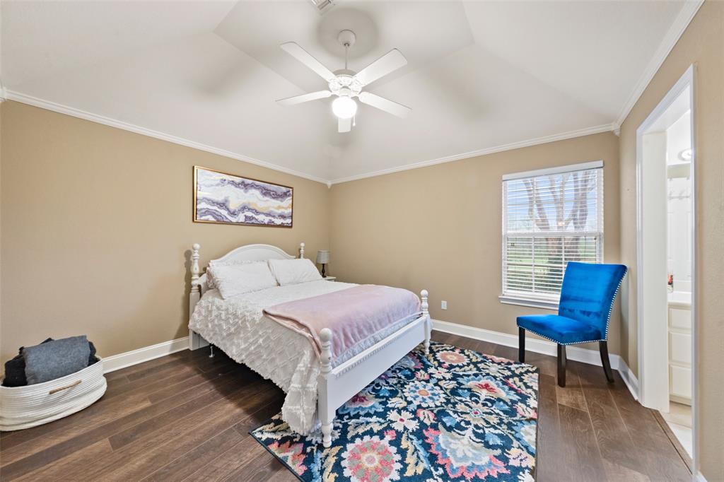 517 Chado Lane Robinson, TX 76706 - Photo 23 of 40 Bedroom #2 featuring ornamental molding, dark wood-type flooring, ensuite bath, a ceiling fan, and lofted ceiling