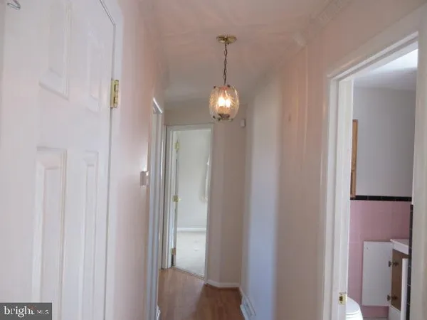 a view of a hallway with windows and chandelier