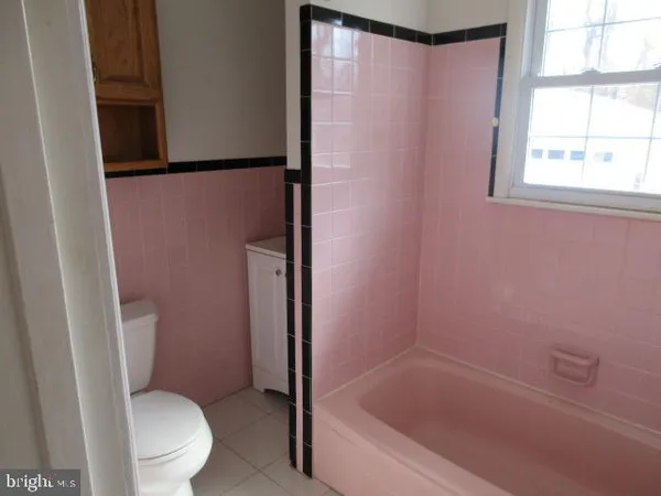 a white toilet sitting next to a bath tub
