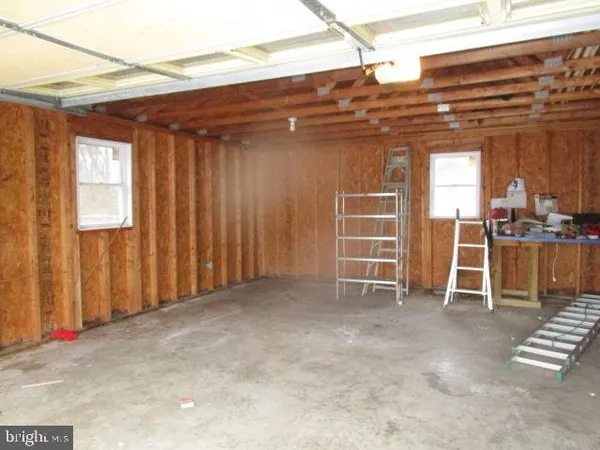 a view of an empty room with wooden walls and stairs