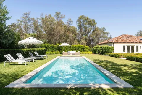 a view of a house with swimming pool and sitting area
