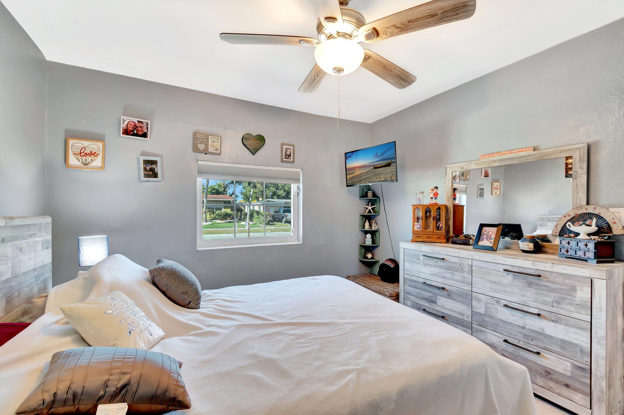 3890 Ocala Road Lake Worth, FL 33462 - Photo 12 of 29 a bedroom with a bed and a chandelier