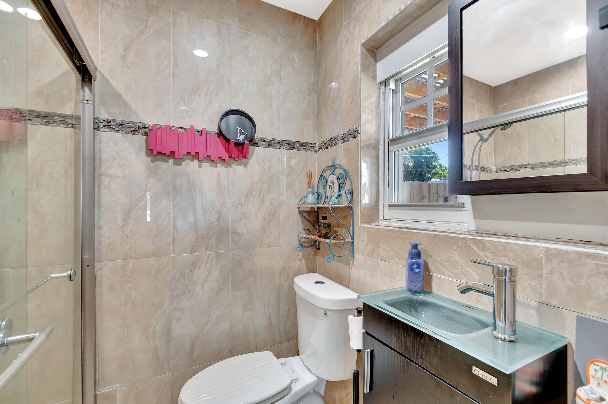 3890 Ocala Road Lake Worth, FL 33462 - Photo 13 of 29 a bathroom with a sink mirror vanity and toilet
