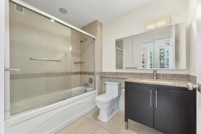 a bathroom with a granite countertop sink mirror toilet and bathtub