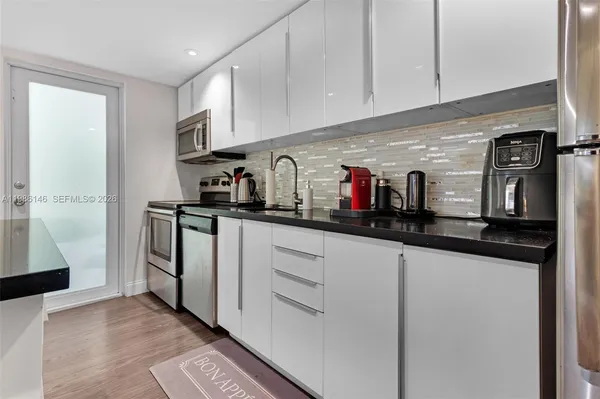 a kitchen with stainless steel appliances granite countertop a refrigerator and a sink