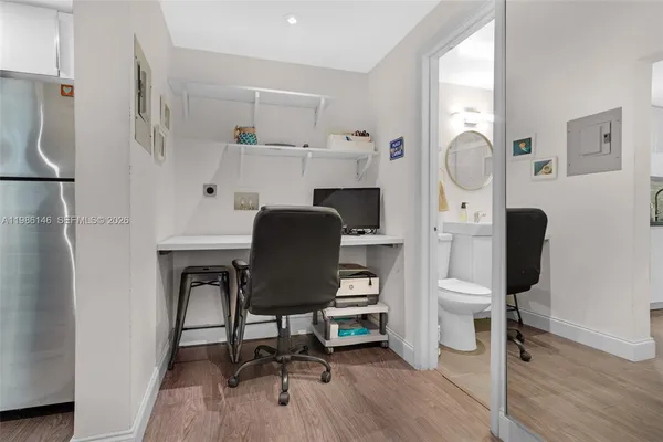 a view of a hallway with workspace and wooden floor