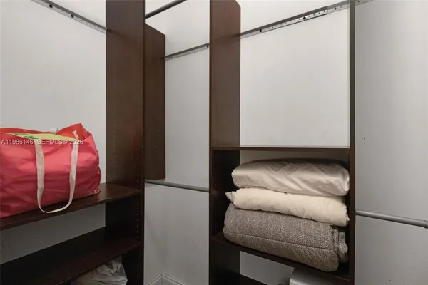 a view of walk in closet with clothes and shoes