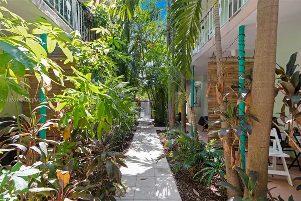 a view of a house with a big yard and palm trees