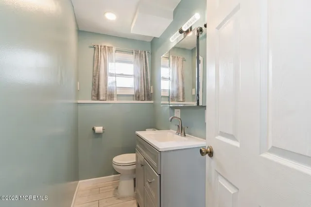 a bathroom with a toilet sink and mirror