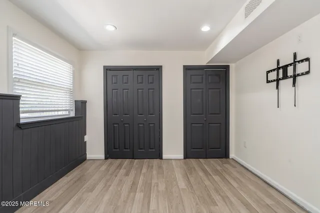 a view of an empty room with closet and a window